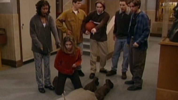Thr group stand around as Mr Feeny is dead on the ground with a knife lodged into his back.