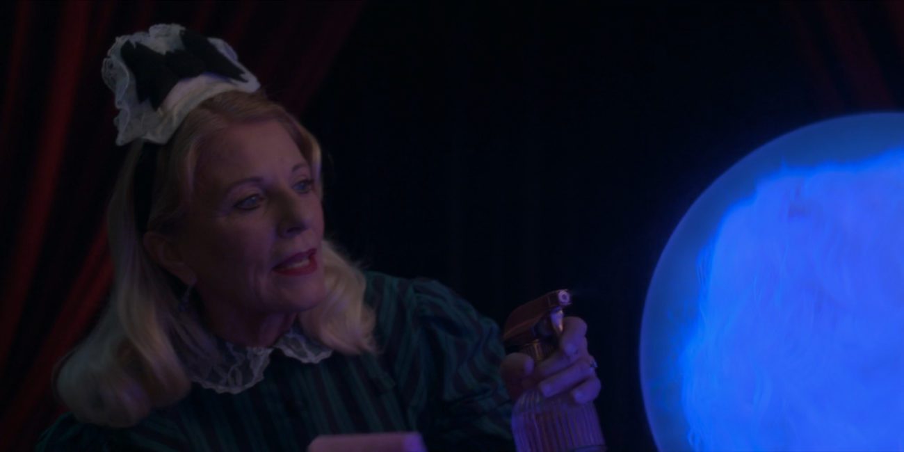 Kim Irvine, a maid, squirts the crystal ball holding the floating head of Madame Pigota (Miss Piggy) with a squirt bottle to clean it, in the 2021 special, "Muppets Haunted Mansion."