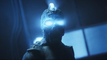 The creature from Parallel Minds stares into the camera with eyes and amohawk of ultra bright blue light