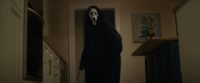 Ghostface stands in a kitchen doorway holding a bloody knife in Scream (2022)