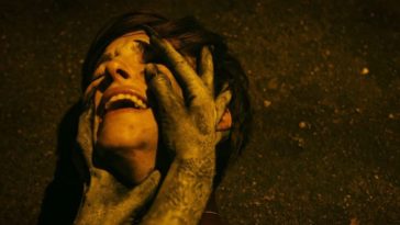 Jane lies on the ground as greyed hands hold her throat and feel her face in Take Back The Night
