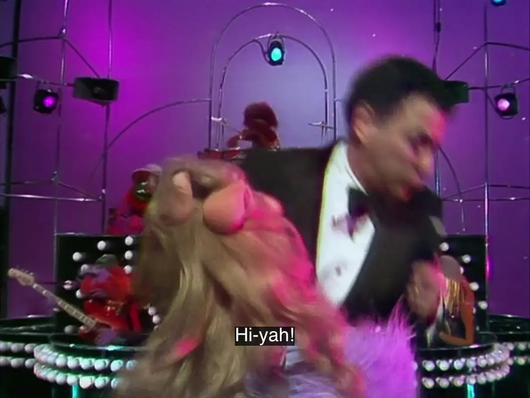 Miss Piggy does a karate chop to Alan Arkin's stomach while yelling, "Hi-yah!", from the TV show, "The Muppet Show."