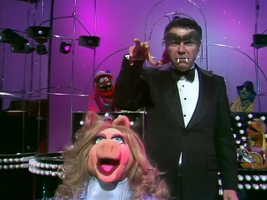 Miss Piggy screams while Alan Arkin lurks behind her in his "Hyde" form with bushy eyebrows and Muppet fangs and one hand reached out toward her, from the TV show, "The Muppet Show."