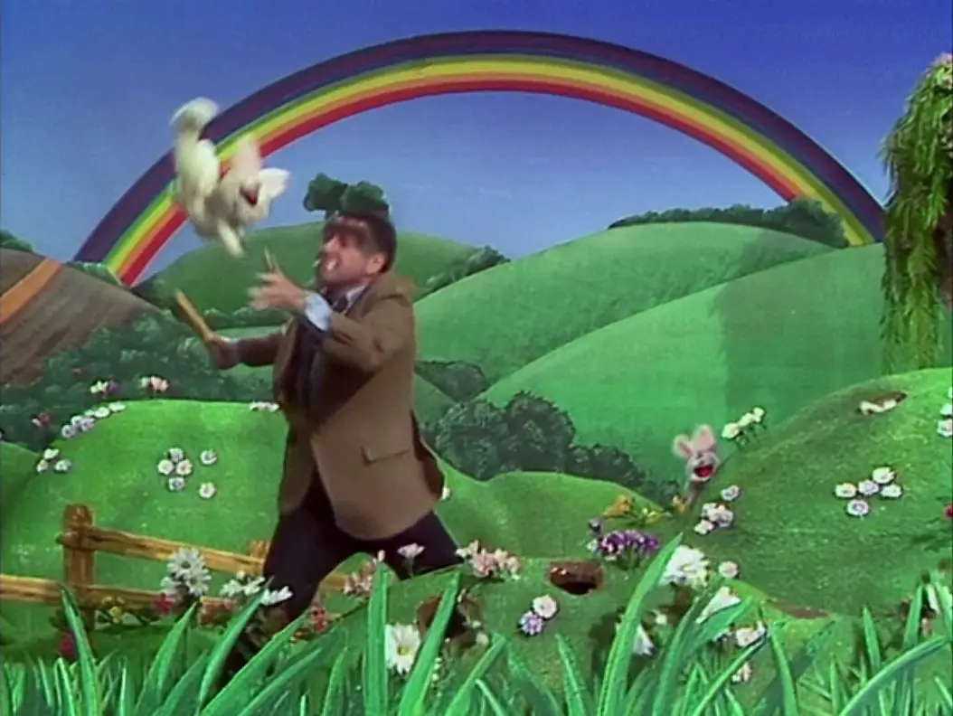 Alan Arkin, in his "Hyde" form, throws a bunny into the air to hit it with a wooden board, from the TV show, "The Muppet Show."