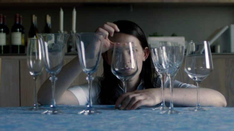 A woman behind a row of fancy glasses