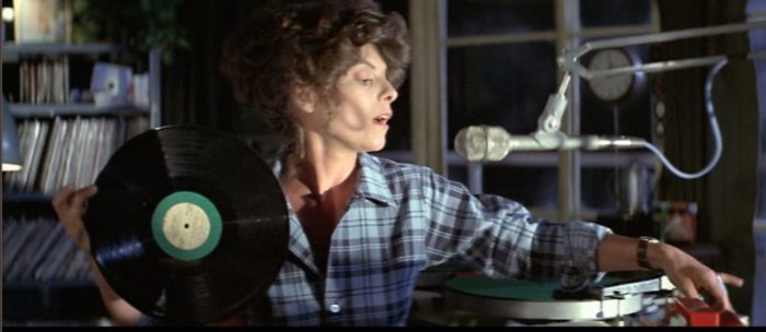 Andrienne Barbou as Stevie Wayne in The Fog switches records on a turntable in the radio station.