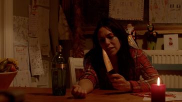 A woman sitting down with a big knife in her hand