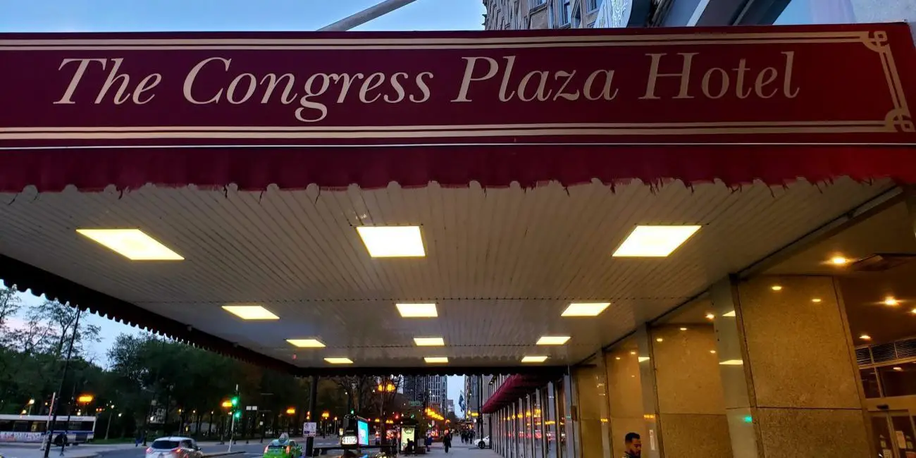 Maroon front awning for the Congress Plaza Hotel with its name in gold letters