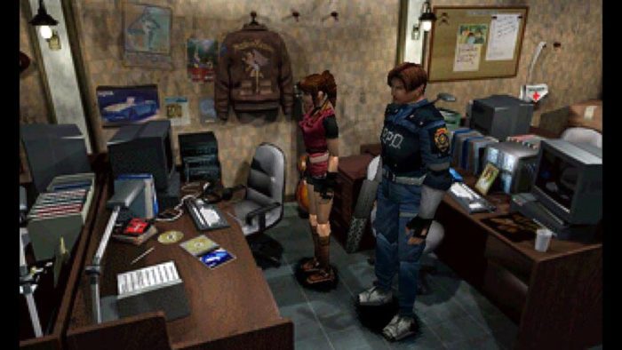 Leon Kennedy and Claire Redfield, standing side by side, look at a cluttered desk in the S.T.A.R.S. office of the Raccoon Police Department.