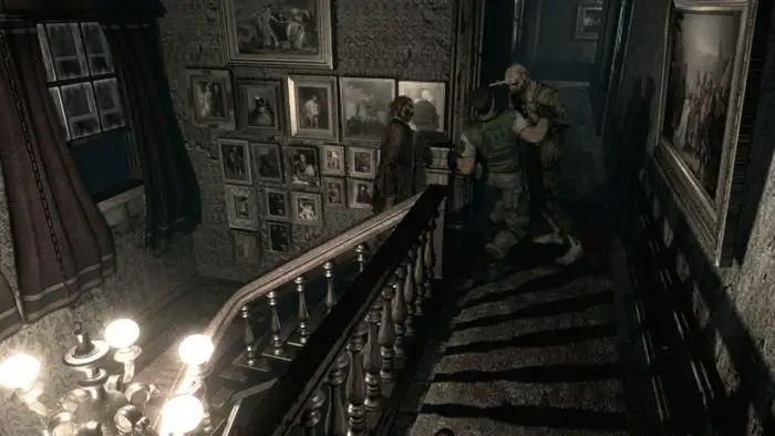 At the top of a Spencer Mansion staircase, Chris Redfield struggles against a zombie with a knife in its head while another zombie ascends the stairs from behind.