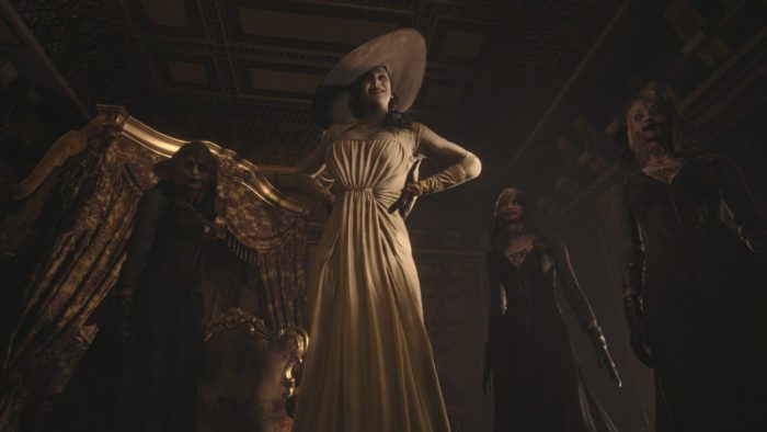 Lady Dimitrescu and her three vampire daughters stand over the player in an ornate palace bedroom.