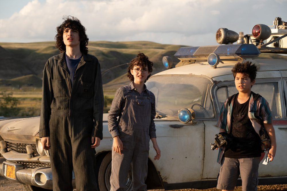 Three kids in front of the Ecto-1