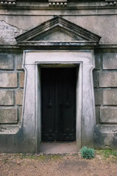 Black doors lead to a mausoleum in Highgate Cemetery