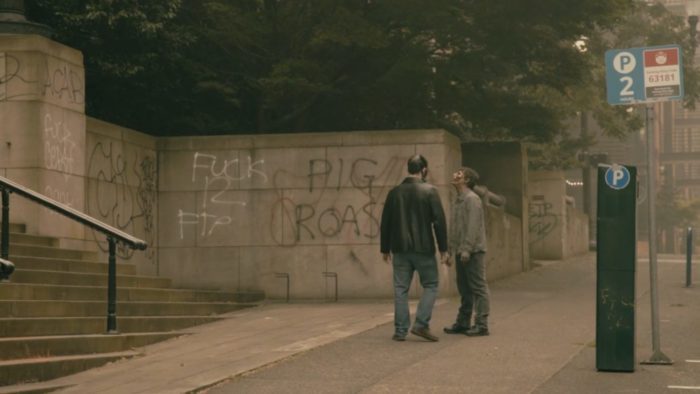 Man takes Zombie for a walk past a graffitied city hall, only adding to the social commentary