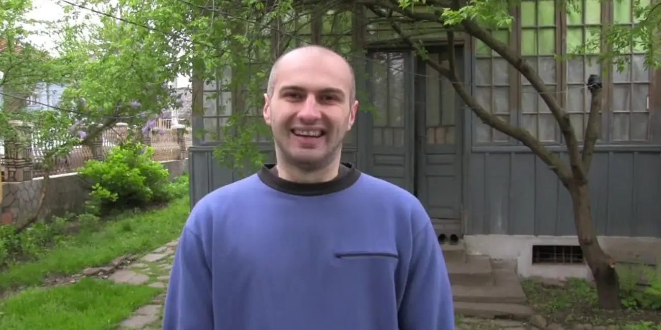 Adrian (Adrian Țofei) grins at the camera as he introduces himself.