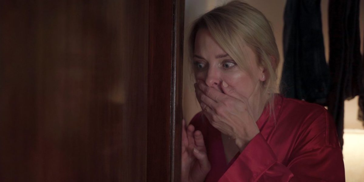 Jessica covers her mouth behind a locked door in Evil at the Door