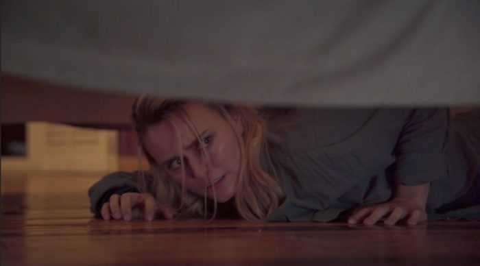 Liz hides under the bed in Evil at the Door