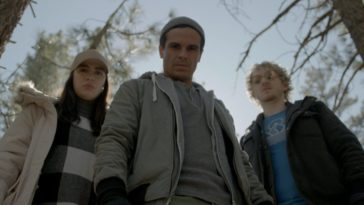 Sarah, Danny, and Michael stand above the camera in the woods of Old Strangers
