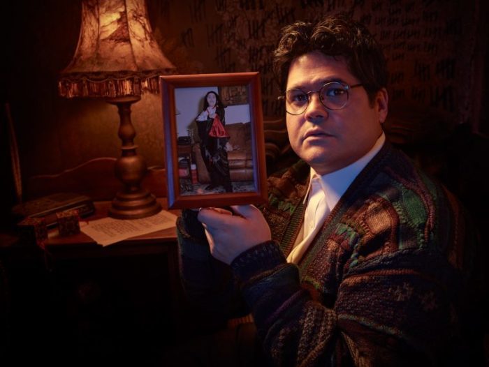 Guillermo holding a framed picture of him as a kid dressed as Armand from Interview with the Vampire