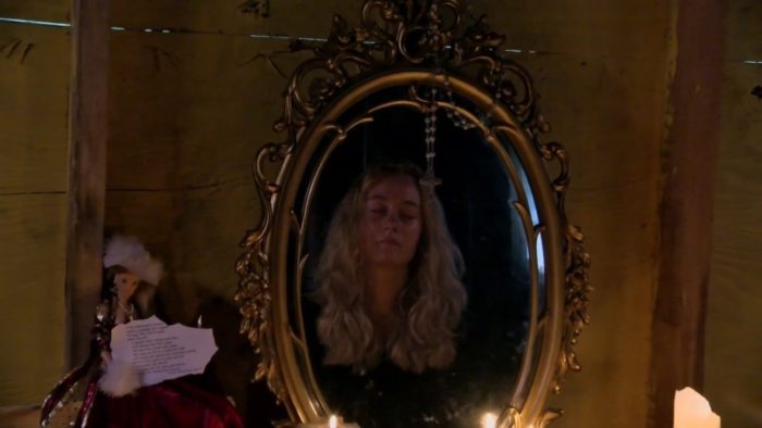 Millie prays into a mirror in Honeycomb