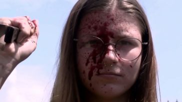 a young girl with a blood-soaked face holds a knife in Honeycomb