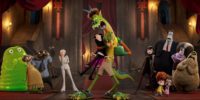 The full cast photo of Hotel Transylvania: Transformania shows Monster Johnny hugging Dracula in the center while the monsters watch aghast on either side of them