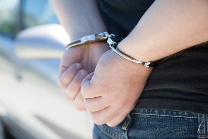 A closeup of wrists bound in handcuffs.