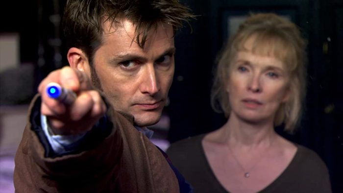 The Tenth Doctor pointing his sonic screwdriver at something off screen, Adelaide standing in the background