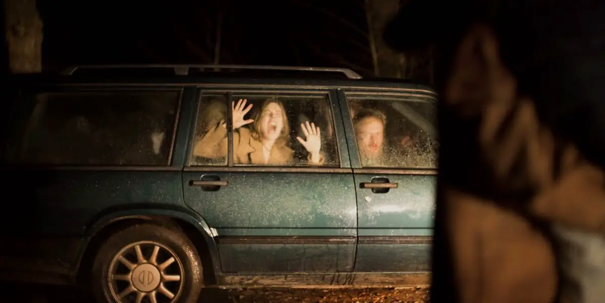 Louise presses her hands to the glass in the back seat of a station wagon as she and Bjørn look on in horror in Speak No Evil