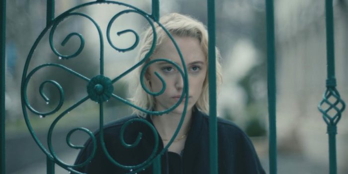 Julia stares through an iron gate in Watcher