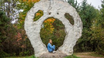 Aurora sitting in an alien-shaped rock formation