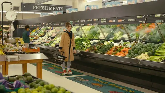 Noa stands in the produce aisle