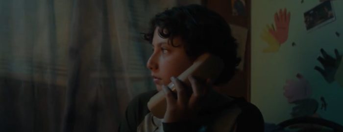 Lucas holding a phone and looking scared