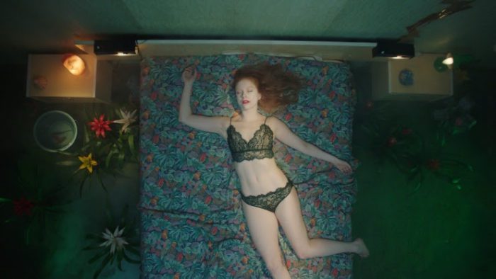 Nora lies on the bed in Hotel Poseidon