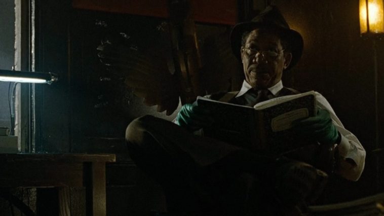 Morgan Freeman sits in a chair reading a book