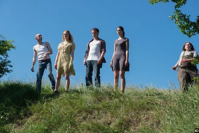 Characters from Leatherface stand atop a grassy hill