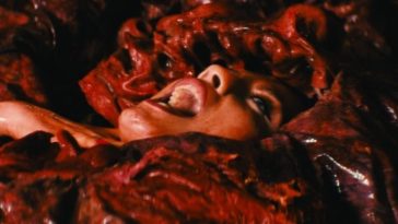 A face is seen shouting from a gory, red presence enveloping a young woman in The Seed