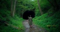A woman walking towards a tunnel