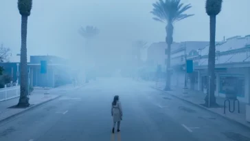 A woman walks a creepy, deserted road