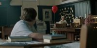 a boy looks back towards a woman holding a balloon in a library
