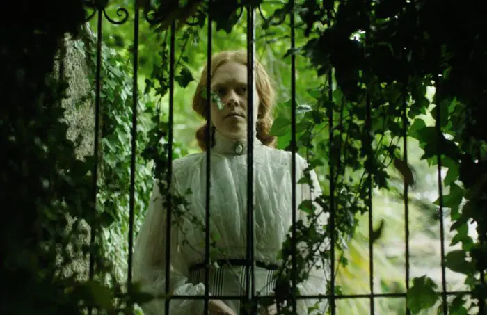 Jane appears behind a locked gate in the garden