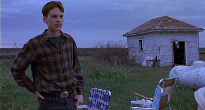 Hilary Swank stands in a field in "Boys Don't Cry"