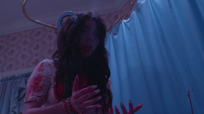 Emma stands in a bathroom covered in blood in Children of Sin