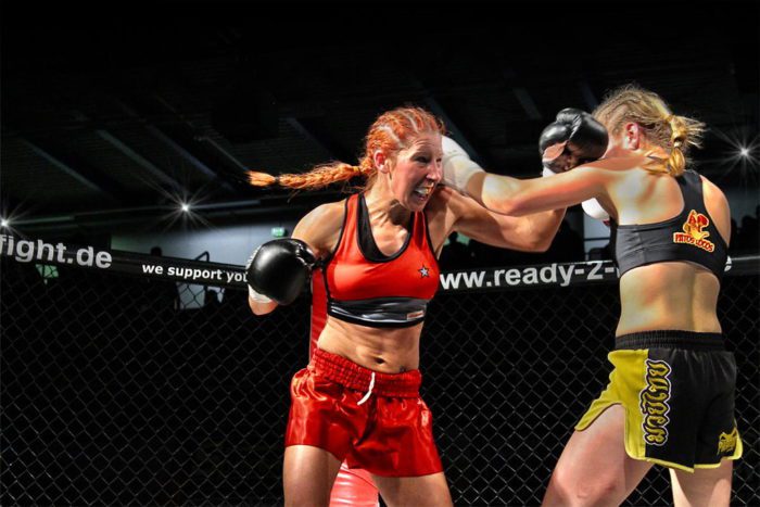 Two female boxers engage in a fight in the ring.