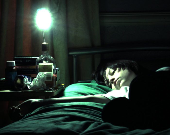 A woman sleeps in a dark room.