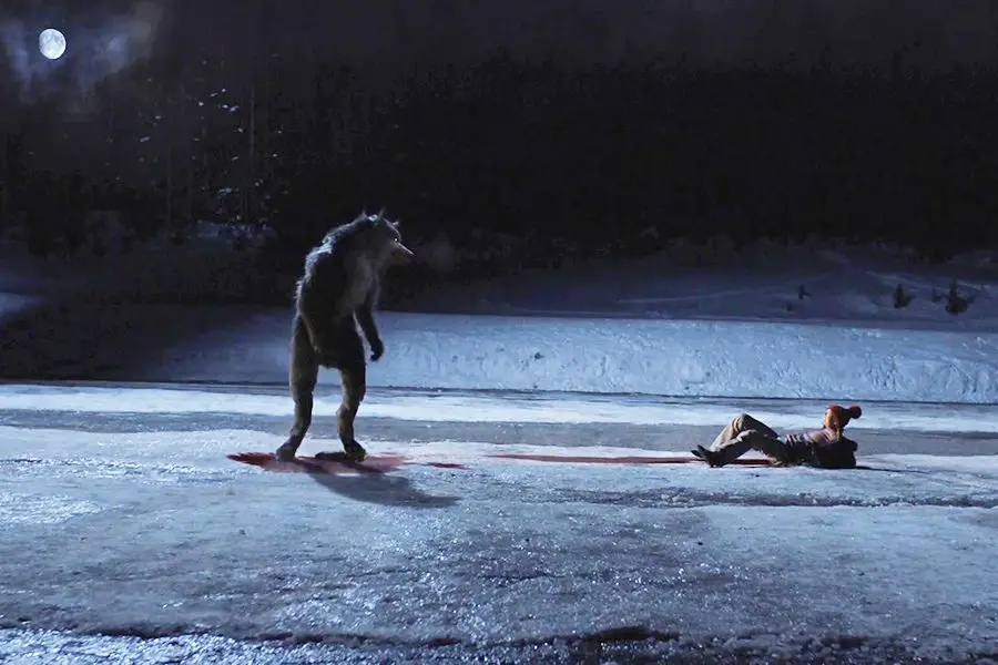 A werewolf stares down its bloody victim in the snow