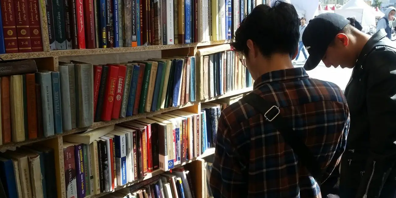 Two young men browse in a book store.
