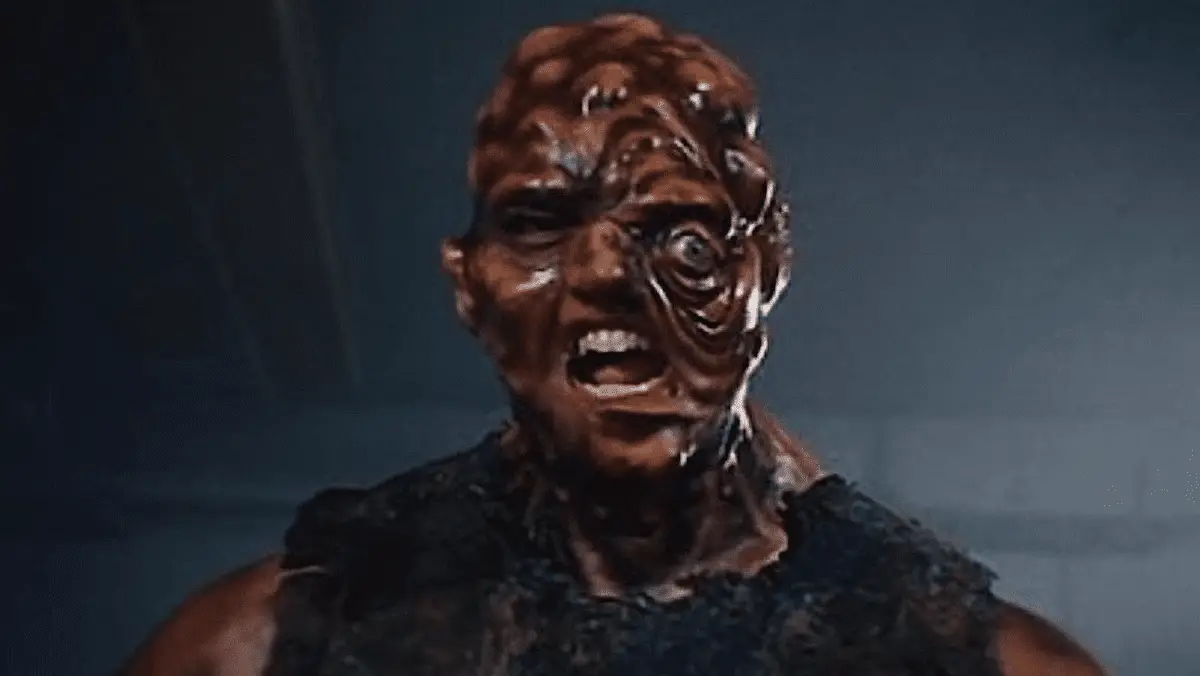 A close up of the Toxic Avenger, a crime-fighting superhero who has been physically deformed and altered after falling into a container of toxic waste.