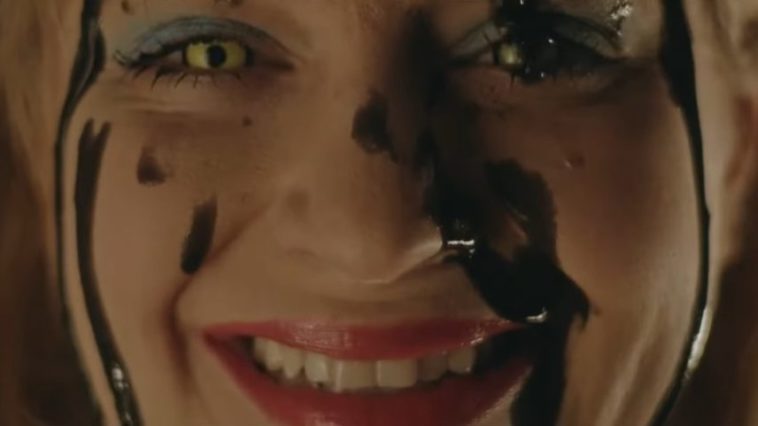 A woman smiling with her face covered in blood