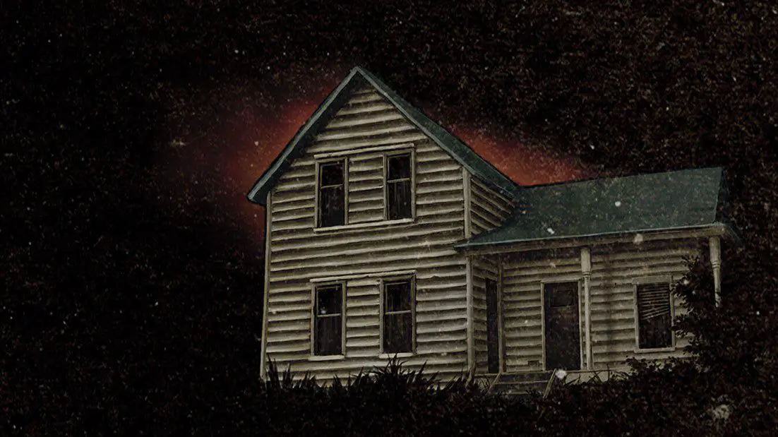 A large house sits against a dark sky